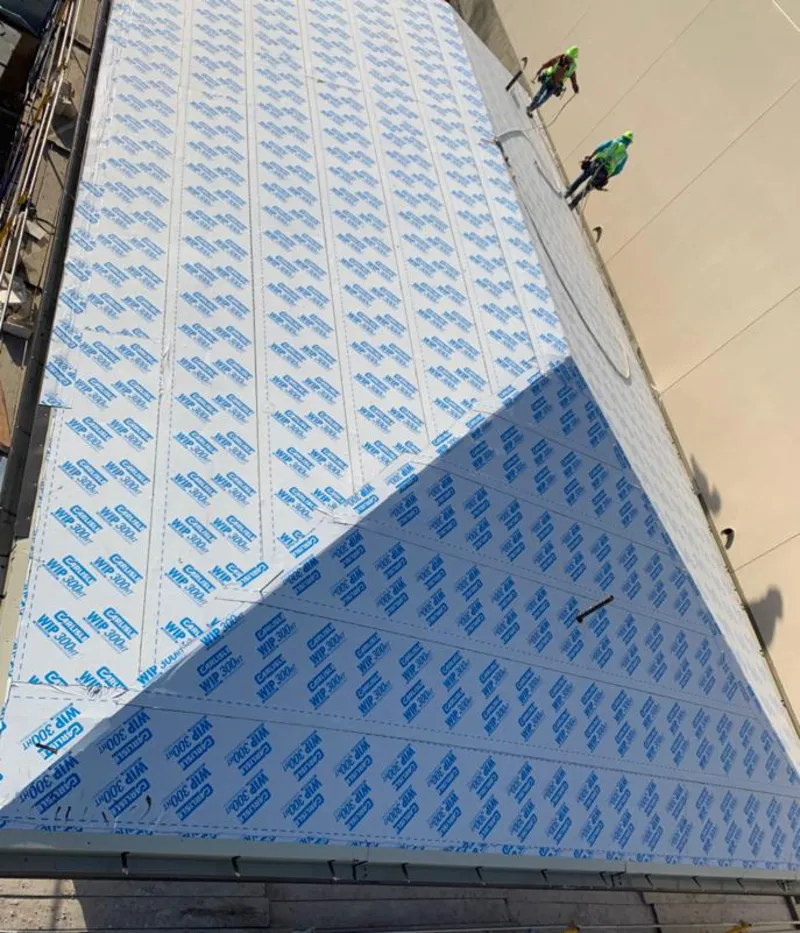 Professional roofers installing underlayment on a metal roof in Mamaroneck